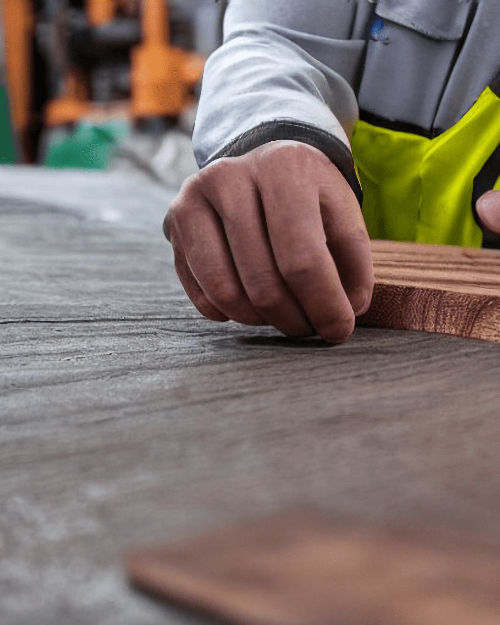 A happy worker working on a rose gum timber board rough pitch of size thickness 40 mm, width of 250 mm and length of 5000 mm